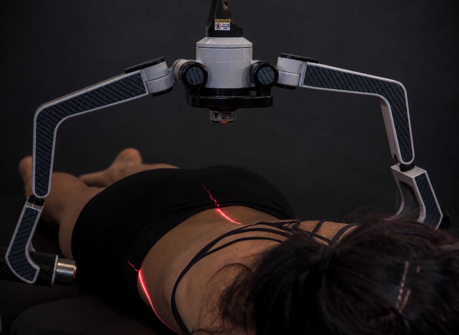 Patient receiving a relaxed, non-invasive FX405 laser therapy session at the neck and shoulder